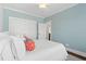 Comfortable bedroom features soft blue walls, a white bedspread and closet with a ceiling fan above at 6514 Anchors Bend Dr Sw, Ocean Isle Beach, NC 28469