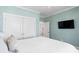Comfortable bedroom features soft blue walls, a white bedspread, closet, and a television at 6514 Anchors Bend Dr Sw, Ocean Isle Beach, NC 28469