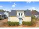 Charming yellow home with inviting balcony, blue accents, and lush landscaping at 6514 Anchors Bend Dr Sw, Ocean Isle Beach, NC 28469