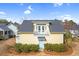 Charming yellow home with a gray roof and balcony, surrounded by lush landscaping at 6514 Anchors Bend Dr Sw, Ocean Isle Beach, NC 28469