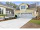 A spacious garage is attached to this charming yellow home with a screened-in porch at 6514 Anchors Bend Dr Sw, Ocean Isle Beach, NC 28469