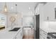 Bright white kitchen with stainless steel appliances, subway tile backsplash, and hardwood floors at 6514 Anchors Bend Dr Sw, Ocean Isle Beach, NC 28469