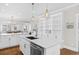 Bright white kitchen with stainless steel appliances, subway tile backsplash, and large center island at 6514 Anchors Bend Dr Sw, Ocean Isle Beach, NC 28469