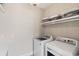 Well-lit laundry room featuring modern washer and dryer units, along with shelving and decorative accents at 6514 Anchors Bend Dr Sw, Ocean Isle Beach, NC 28469