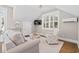 Cozy living room with shiplap walls, a comfortable sofa, chair, and large windows at 6514 Anchors Bend Dr Sw, Ocean Isle Beach, NC 28469