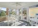 Relaxing screened porch with white table, chairs, and ceiling fan at 6514 Anchors Bend Dr Sw, Ocean Isle Beach, NC 28469