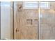 Glass enclosed shower featuring stone-look tile walls, a built-in niche, and a rainfall shower head at 6514 Anchors Bend Dr Sw, Ocean Isle Beach, NC 28469