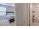 Bedroom with neutral carpeting, a ceiling fan, a window, a bed with a blue-and-white comforter, and an open doorway to the bathroom at 693 Landmark Cove Rd., Carolina Shores, NC 28467