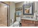 Bright bathroom featuring a glass shower, vanity with granite counters, and decorative mirror at 9547 Edgerton Dr. # Ph1005, Myrtle Beach, SC 29572