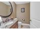 Compact powder room with granite vanity, decorative mirror, and convenient toilet at 9547 Edgerton Dr. # Ph1005, Myrtle Beach, SC 29572