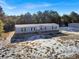 Exterior view of a gray single-story home with black shutters surrounded by trees and a clear blue sky at 1455 Francis Marion Dr., Georgetown, SC 29440