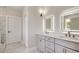 Modern bathroom featuring double vanity, illuminated mirrors, white cabinets, and a marble tile floor at 1007 Brood Ct., Conway, SC 29526