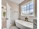 Relaxing bathroom with soaking tub, marble tile, and a large window offering plenty of natural light at 1007 Brood Ct., Conway, SC 29526