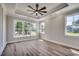 Spacious bedroom with tray ceiling, large windows offering scenic views, and luxury vinyl plank flooring at 1007 Brood Ct., Conway, SC 29526