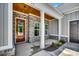 Inviting front porch featuring brick accents, white columns, and a wooden front door with glass panels at 1007 Brood Ct., Conway, SC 29526