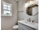 Stylish powder room featuring modern vanity, elegant mirror, fixtures, and a window for natural light and ventilation at 1007 Brood Ct., Conway, SC 29526