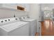 Functional laundry room featuring white washer and dryer, cabinetry, and wood-look flooring at 1021 Dunraven Ct., Conway, SC 29527