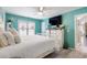 Bright bedroom with light teal walls, white furniture and large flatscreen television at 1031 N Dogwood Dr., Surfside Beach, SC 29575