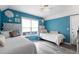 Cozy bedroom with blue accent walls, twin beds, and bright natural light from the window at 1031 N Dogwood Dr., Surfside Beach, SC 29575