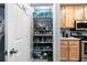 Walk-in pantry featuring an organized storage area, shelves filled with various food items, and nearby kitchen cabinets at 1031 N Dogwood Dr., Surfside Beach, SC 29575