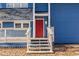 The front door with red paint and sidelight on a blue home at 109 Clemson Rd., Conway, SC 29526