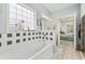 Bright bathroom showcasing a soaking tub with decorative tile and a large window, adjacent to a bedroom at 109 Jessica Lakes Dr., Conway, SC 29526