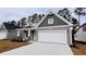 The home has a large two-car garage, craftsman-style architecture, and well-maintained landscaping at 1091 Forest Bend Dr., Calabash, NC 28467