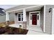 The inviting front porch has stone accents, white columns and a red front door at 1091 Forest Bend Dr., Calabash, NC 28467