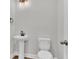 Simple powder room featuring pedestal sink, toilet, and modern lighting fixtures at 1091 Forest Bend Dr., Calabash, NC 28467