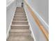 Carpeted staircase with a wooden handrail, leading to the upper level of the home at 1091 Forest Bend Dr., Calabash, NC 28467