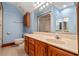 Bathroom with wood cabinets, blue walls, and a large mirror at 1110 Links Rd., Myrtle Beach, SC 29575