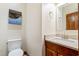 Bathroom features a white toilet and wood vanity with marble countertop and a flamingo picture at 1110 Links Rd., Myrtle Beach, SC 29575