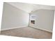 A bedroom with neutral walls and carpet floors features a bright, single window at 1111 Forest Bend Dr., Calabash, NC 28467