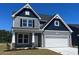 Beautiful two-story home with a two car garage and gray siding against a blue sky at 1111 Forest Bend Dr., Calabash, NC 28467