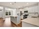 Spacious kitchen showcasing stainless steel appliances, white cabinets, quartz counters, and hardwood floors at 1111 Forest Bend Dr., Calabash, NC 28467