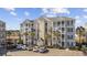 A full exterior of the building, featuring multiple floors, staircases, and a parking area with several cars at 117 Ella Kinley Circle # 302, Myrtle Beach, SC 29588