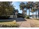 A view of the side of a beautiful condominium next to a lakeside walkway lined with palm trees at 129 Hartland Dr. # 8-I, Myrtle Beach, SC 29572