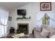 Cozy living room features fireplace with mantel, neutral colors, and lots of light from large window at 129 Hartland Dr. # 8-I, Myrtle Beach, SC 29572