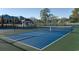 A well-maintained tennis court with a blue surface surrounded by a secure fence at 129 Hartland Dr. # 8-I, Myrtle Beach, SC 29572