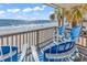 A balcony overlooking the beach has chairs for relaxing and enjoying the view at 1310 N Waccamaw Dr. # 208, Garden City Beach, SC 29576