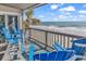 Inviting oceanfront balcony with comfortable blue Adirondack chairs, offering stunning ocean views at 1310 N Waccamaw Dr. # 208, Garden City Beach, SC 29576