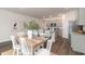 Dining area with a wooden table, white chairs, and an open view of the kitchen at 141 Leyland Cypress Dr, Conway, SC 29527