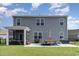 Back exterior of home featuring a screened porch, patio set, grill, and slider, perfect for outdoor living and entertaining at 1504 Oyster Bay Ct., Myrtle Beach, SC 29588