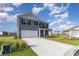 Attractive gray two-story home with a well-manicured lawn and a long concrete driveway at 1504 Oyster Bay Ct., Myrtle Beach, SC 29588