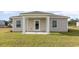 A covered back porch framed by white columns overlooks a lush green lawn, ideal for outdoor relaxation at 153 Leyland Cypress Dr, Conway, SC 29527