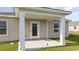 Covered patio in backyard with white support pillars, door and backyard views at 153 Leyland Cypress Dr, Conway, SC 29527