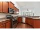 Open kitchen area with a stainless steel range, microwave, and dark wood cabinets at 156 Parmelee Dr. # B, Murrells Inlet, SC 29576