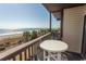 This balcony is overlooking the beach, with a table and chairs for enjoying the ocean view at 201 N 76Th Ave. N # B-2, Myrtle Beach, SC 29572