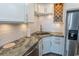 Close-up of kitchen details including a corner sink, tile backsplash, stainless steel appliances, and custom wine rack at 201 N 76Th Ave. N # B-2, Myrtle Beach, SC 29572