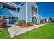 Charming exterior view of a blue condo with a walkway, landscaped lawn, and nearby parking at 2151 Clearwater Dr. # C, Surfside Beach, SC 29575